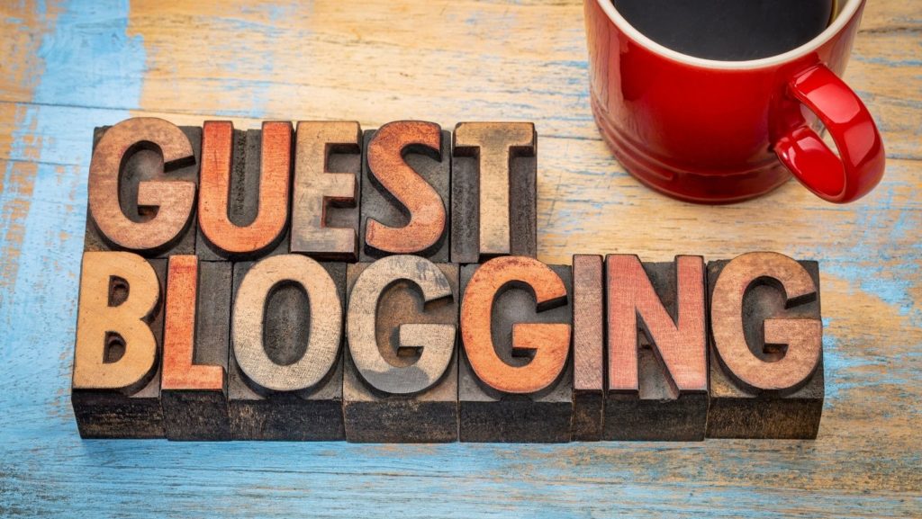 the words guest blogging written our of typesetting letters with a cup of coffee in the corner