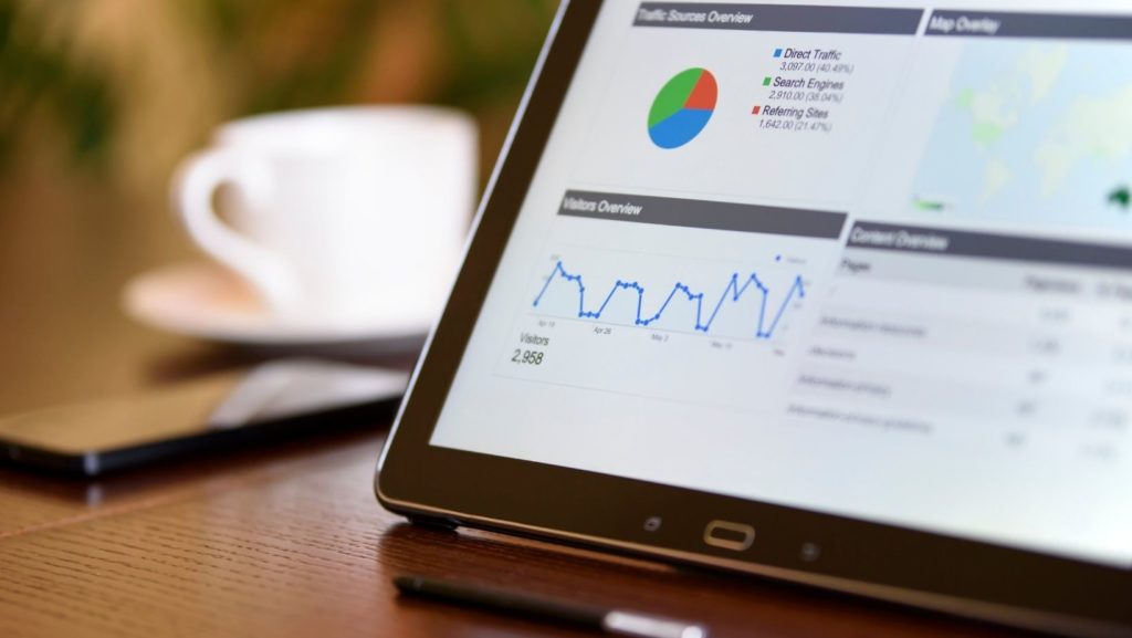 Tablet with SEO graphs in the foreground and a coffee cup in the background