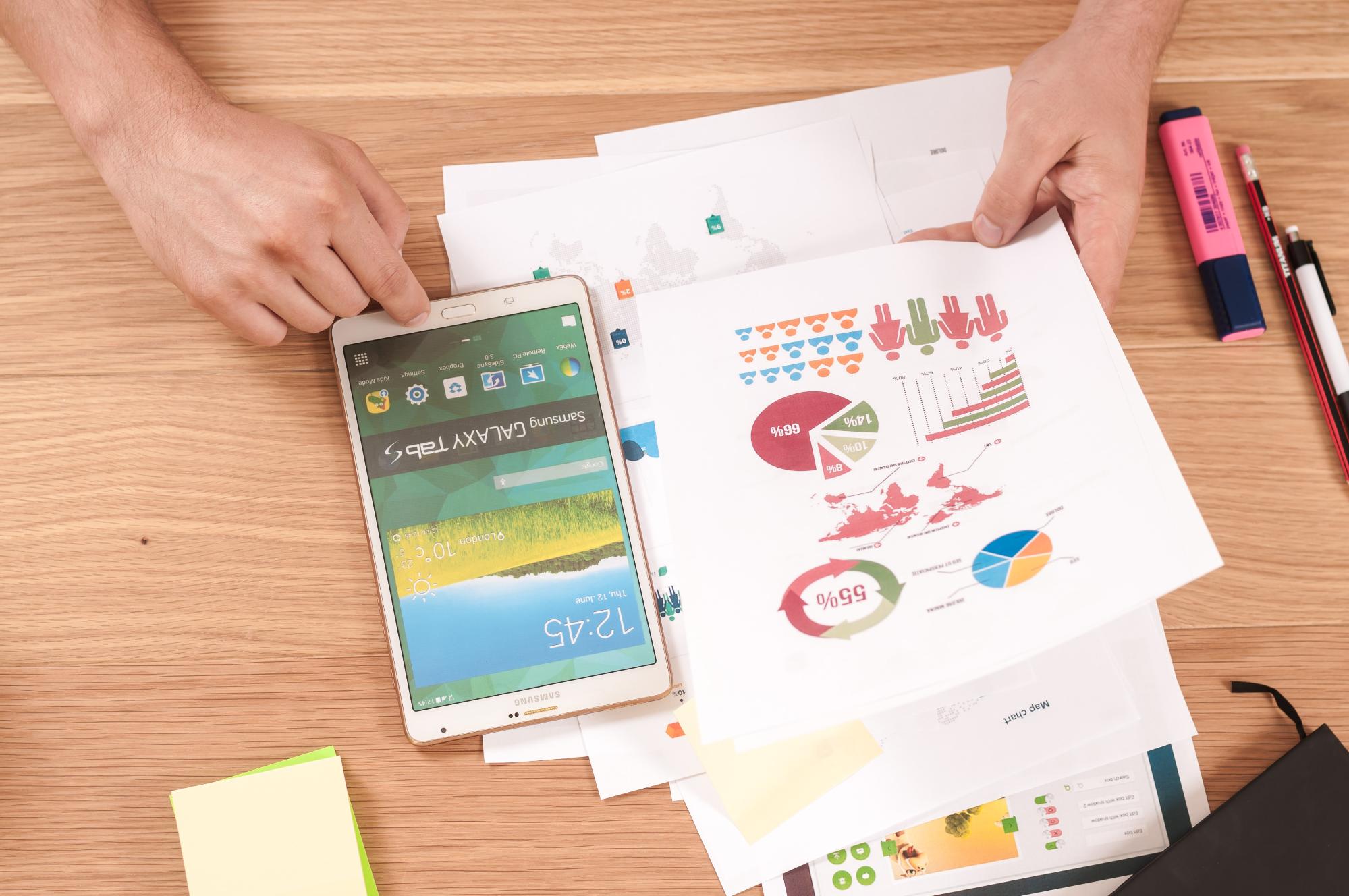 A smart phone and a print out of graphs on a tabletop