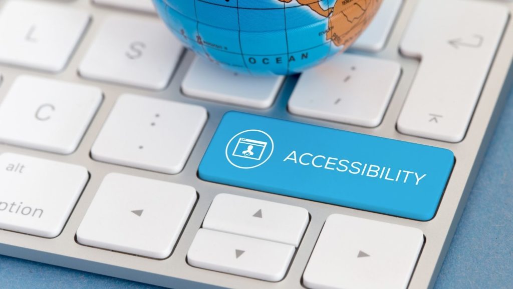 A keyboard with a blue button that says accessibility instead of enter with a mini globe at the top