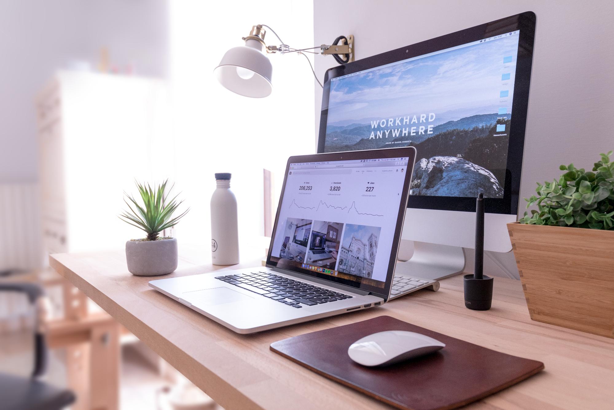A laptop with monitor behind on a desk with mouse beside showing website with visual hierarchy